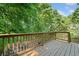 Spacious wooden deck with railing overlooks a lush green backyard surrounded by mature trees at 2346 Unicoi Ct, Duluth, GA 30097