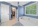 Bright bathroom with a tub and tiled floor next to a door with a walk-in closet at 2346 Unicoi Ct, Duluth, GA 30097