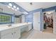 Bright bathroom features double sink vanity, large mirror, and access to a walk-in closet at 2346 Unicoi Ct, Duluth, GA 30097