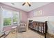 Charming Bedroom with lavender walls, rocking chair, and a dark wood crib at 2346 Unicoi Ct, Duluth, GA 30097