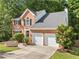 Traditional two-story brick home with a two-car garage, well-kept lawn, and manicured landscaping at 2346 Unicoi Ct, Duluth, GA 30097