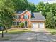 Traditional brick home with a two-car garage, lush lawn, and a long driveway leading to the tree-lined street at 2346 Unicoi Ct, Duluth, GA 30097