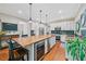 Bright kitchen features a large island with wood countertop and wine cooler, hardwood floors, stainless steel appliances, and tiled backsplash at 2346 Unicoi Ct, Duluth, GA 30097