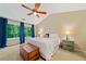Bright main bedroom includes a large bed, two side tables, hardwood floors, and large windows overlooking the backyard at 2346 Unicoi Ct, Duluth, GA 30097