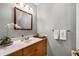 Bathroom features a wood vanity with solid surface counter, decorative mirror and lighting at 2349 Northlake Ne Ct, Atlanta, GA 30345