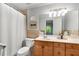 Neutral toned bathroom with a white shower curtain, vanity, mirror and modern lighting at 2349 Northlake Ne Ct, Atlanta, GA 30345