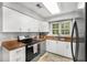 Well-lit kitchen features white cabinets, stainless steel appliances, and a window view at 2349 Northlake Ne Ct, Atlanta, GA 30345