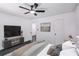 Modern bedroom with dark floors, ceiling fan, television, and neutral decor at 5490 Chemin De Vie, Sandy Springs, GA 30342