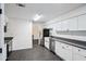 Updated kitchen with white cabinets, stainless steel appliances, and gray tile floors at 5490 Chemin De Vie, Sandy Springs, GA 30342