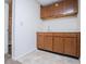 Wet bar area with oak cabinets, light countertop, backsplash, and light tile flooring at 6026 Belle Meade Ct, Villa Rica, GA 30180