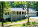 Charming home featuring a welcoming front porch, a two-car garage, and mature trees at 6026 Belle Meade Ct, Villa Rica, GA 30180