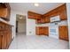 An inviting kitchen with wooden cabinets, white appliances, and tile flooring leading to another room at 6026 Belle Meade Ct, Villa Rica, GA 30180