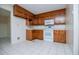 Cozy kitchen featuring wooden cabinets, white appliances, and tiled flooring, offering a functional cooking space at 6026 Belle Meade Ct, Villa Rica, GA 30180