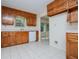 Bright kitchen area featuring wooden cabinetry, white appliances, and tiled floors, providing ample natural light and space at 6026 Belle Meade Ct, Villa Rica, GA 30180