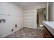 Functional laundry area with open shelving, tile flooring, and convenient utility connections, designed for efficient home management at 6026 Belle Meade Ct, Villa Rica, GA 30180