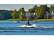 Waterfront view of the lake and boaters enjoying recreational activities on a sunny day at 6026 Belle Meade Ct, Villa Rica, GA 30180