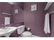 The powder room has a modern pedestal sink, framed art, and plum colored walls at 1421 Peachtree Ne St # 212, Atlanta, GA 30309