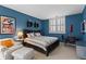 Bright blue bedroom with queen-sized bed, large window, seating area, and dark furniture at 1421 Peachtree Ne St # 212, Atlanta, GA 30309