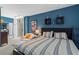 Spacious blue bedroom with a queen bed, large window, decor, and closet doors at 1421 Peachtree Ne St # 212, Atlanta, GA 30309