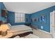 Stylish blue bedroom features a queen bed, shuttered window, and modern furnishings at 1421 Peachtree Ne St # 212, Atlanta, GA 30309