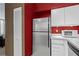 The kitchen features stainless steel appliances and white cabinetry, set against a red accent wall at 1421 Peachtree Ne St # 212, Atlanta, GA 30309