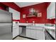 Efficient kitchen with stainless steel appliances, white cabinetry, and bright red accent wall at 1421 Peachtree Ne St # 212, Atlanta, GA 30309