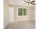 Comfortable bedroom featuring neutral carpeting, ceiling fan and a sunlit window at 2895 Fairview Rd, Covington, GA 30016