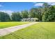 Long driveway leading up to a charming single-story home surrounded by lush greenery at 2895 Fairview Rd, Covington, GA 30016