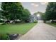 Beautiful home with mature trees and a long driveway leading up to the house and attached garage at 4130 Providnce Square, Alpharetta, GA 30009