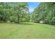 Extensive backyard showcasing a large grassy area with mature trees and a shed or RV, offering ample space at 12510 Georgia 36, Covington, GA 30014