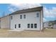 Back of the house with light gray siding, black roof, windows and a small patio at 408 Westmarch Cir, Loganville, GA 30052