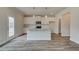 Open concept kitchen with white cabinets, granite countertops, stainless appliances, kitchen island and wood-look floors at 408 Westmarch Cir, Loganville, GA 30052