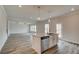 Bright kitchen with white cabinets, granite countertops, island, and stainless dishwasher flowing into living area at 408 Westmarch Cir, Loganville, GA 30052