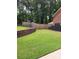 Spacious backyard featuring a retaining wall, lush lawn, and privacy fence at 6210 Douglas Manor Ct, Douglasville, GA 30134