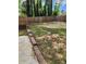 Wide backyard with wooden fence and retaining wall featuring mature trees and plenty of room for entertaining at 6210 Douglas Manor Ct, Douglasville, GA 30134