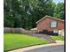 Spacious backyard showcasing a well-maintained lawn, brick retaining wall, and privacy fence at 6210 Douglas Manor Ct, Douglasville, GA 30134