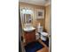 Bathroom featuring a pedestal sink, a toilet, a mirror, and framed artwork at 6210 Douglas Manor Ct, Douglasville, GA 30134