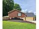 Back exterior of brick home, featuring a two-car garage and a lush green lawn at 6210 Douglas Manor Ct, Douglasville, GA 30134