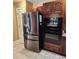 Stainless steel refrigerator and oven combo in a kitchen with wood cabinetry at 6210 Douglas Manor Ct, Douglasville, GA 30134