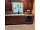 A kitchen featuring cherry wood cabinetry, granite countertops, tile backsplash, stainless steel dishwasher, and a farmhouse sink at 6210 Douglas Manor Ct, Douglasville, GA 30134