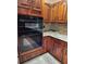 Modern kitchen with built-in double oven, granite countertops and wood cabinets at 6210 Douglas Manor Ct, Douglasville, GA 30134