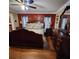 A primary bedroom with an ornate dark wood bed, dressers and shiny hardwood floors at 6210 Douglas Manor Ct, Douglasville, GA 30134