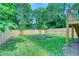 This backyard features a wood fence, green grass and landscaping with lots of mature trees for privacy at 862 Hobson Street Southwest Sw St, Atlanta, GA 30310