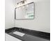 Modern bathroom vanity with black countertop, rectangular mirror, and sleek faucet at 862 Hobson Street Southwest Sw St, Atlanta, GA 30310