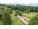 Scenic view of the property showcasing the long driveway, fenced-in fields, and abundance of mature trees at 980 Casteel Rd, Powder Springs, GA 30127