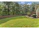 Spacious, level backyard with lush green grass, mature trees, and a wooden fence at 980 Casteel Rd, Powder Springs, GA 30127