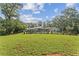 Wide backyard view with a green lawn, wooden fence, mature trees, and a home in the background at 980 Casteel Rd, Powder Springs, GA 30127