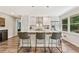Stylish kitchen island with seating, white cabinetry, stainless steel appliances, and hardwood floors at 980 Casteel Rd, Powder Springs, GA 30127