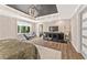 Spacious main bedroom featuring a dark tray ceiling, hardwood floors, exercise equipment, and a stylish light fixture at 980 Casteel Rd, Powder Springs, GA 30127