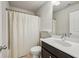 Bright bathroom featuring a shower with patterned curtain, toilet, and vanity with dark wood cabinets at 2817 White Oak Ln, Decatur, GA 30032